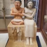 Egyptian statue of couple sitting on a stone
