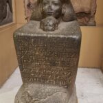 Egyptian statue carved with hieroglyphics on stone